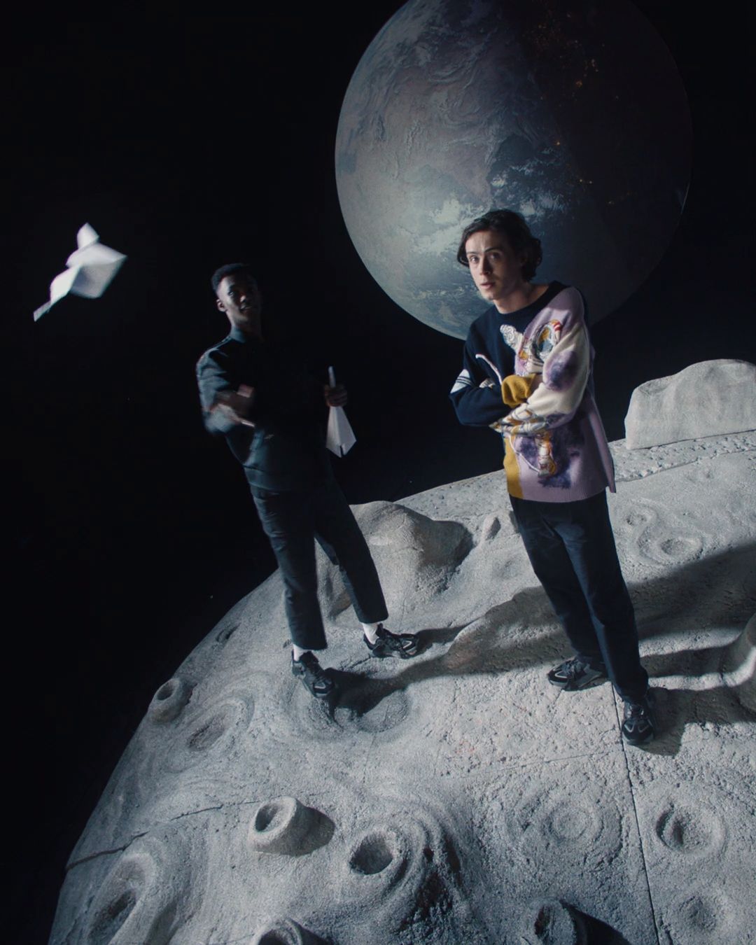 a couple of people standing on top of a moon