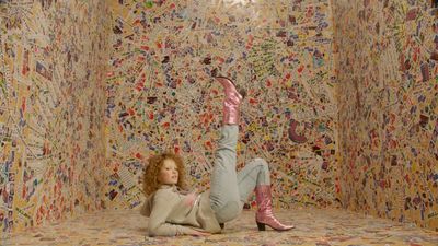 a woman laying on the ground in front of a wall