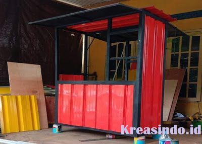 a small red and black building in a warehouse