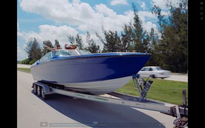 a blue and white boat being towed on a trailer