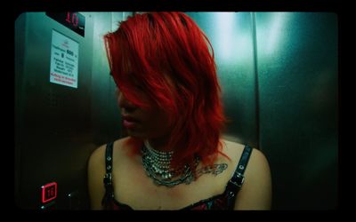 a woman with red hair standing in a elevator