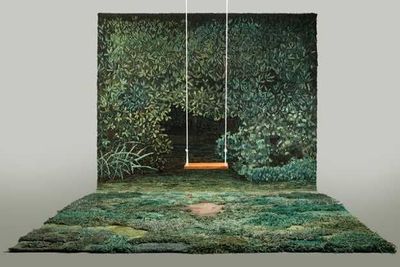 a green carpet with a swing hanging from it