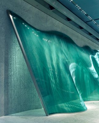 a large green wave sculpture in a building