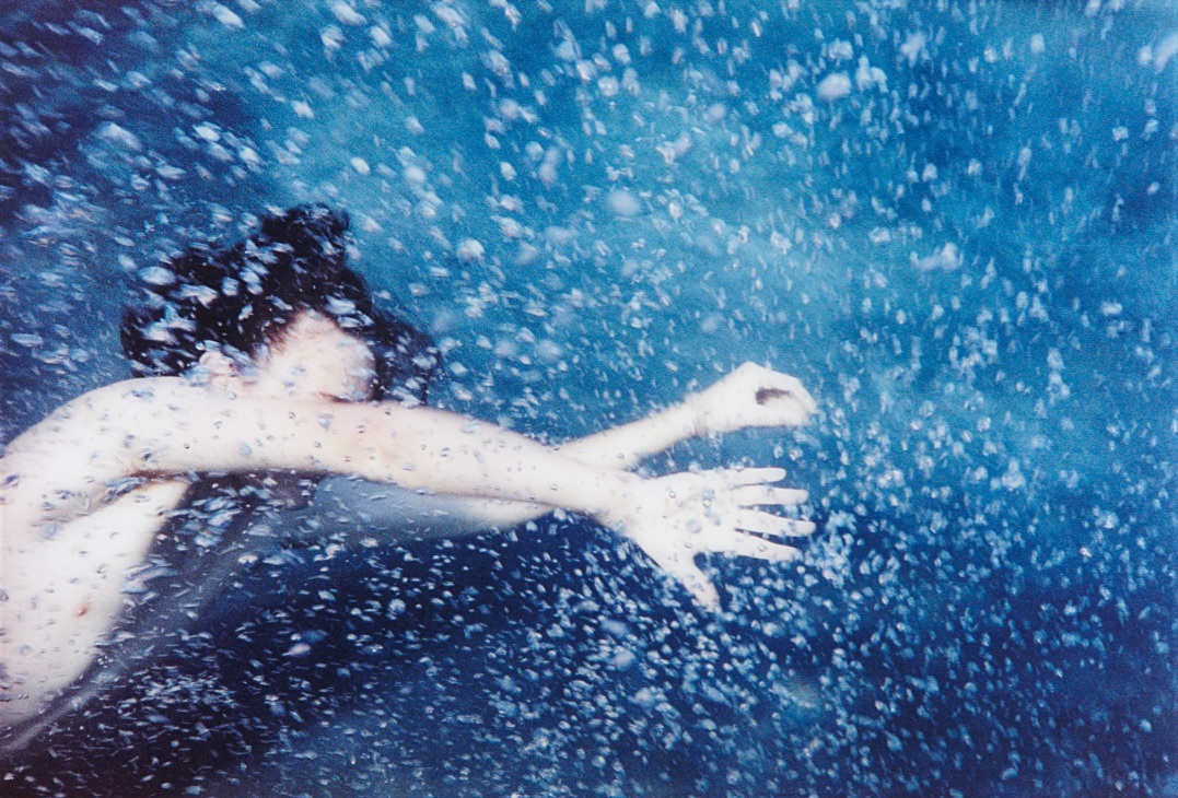 a woman floating in the water with her arms outstretched