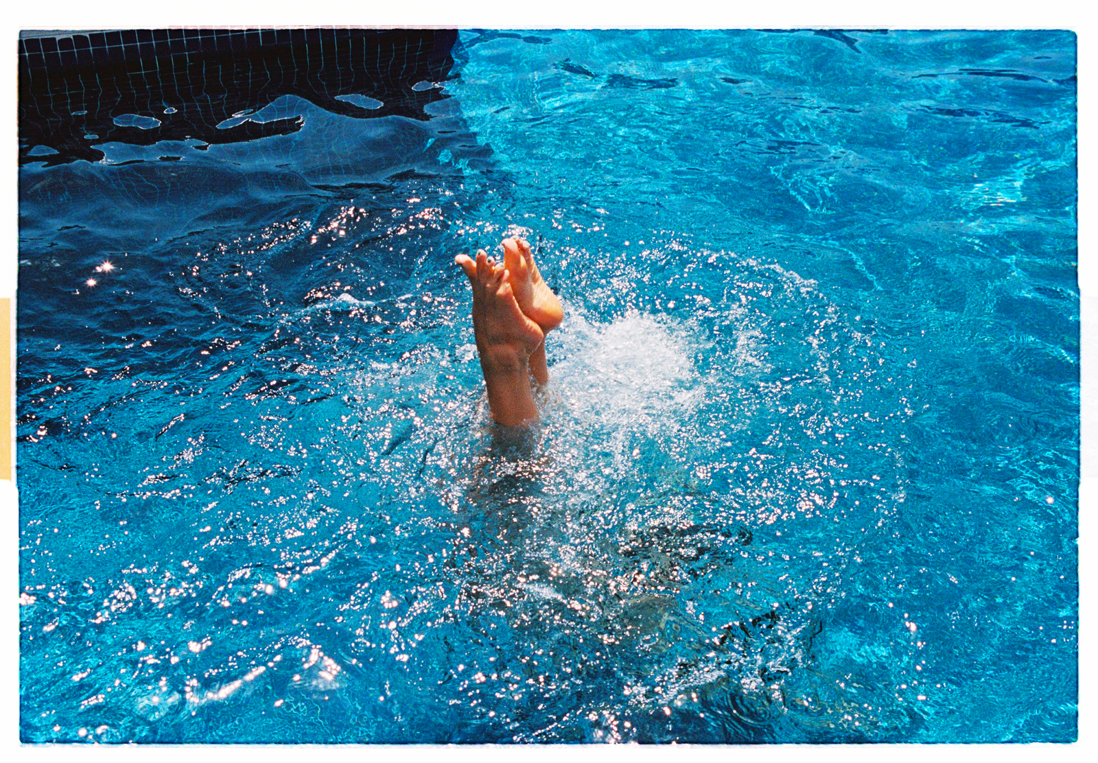 a person swimming in a pool with their feet in the water