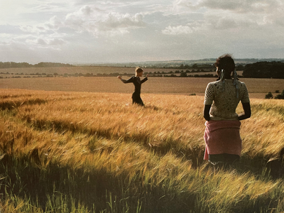 a couple of people standing in a field of grass