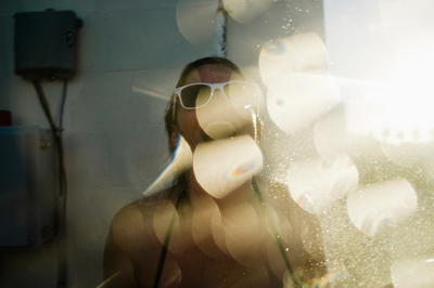 a woman with sun glasses standing in front of a mirror