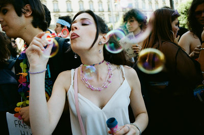 a woman blowing bubbles in a crowd of people