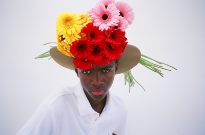 a woman wearing a hat with flowers on it