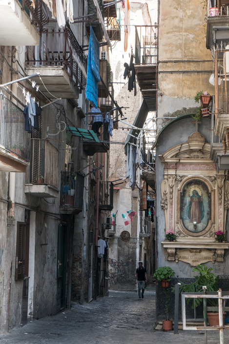 a person walking down a narrow alley way