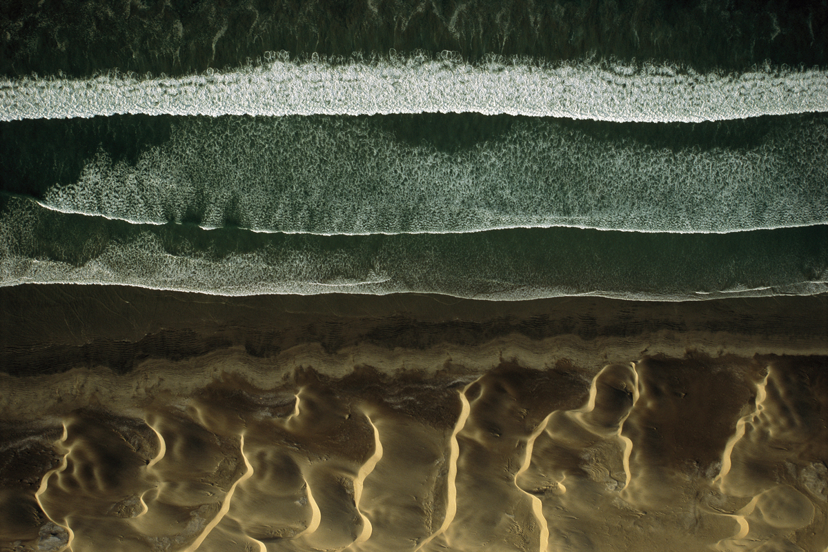 an aerial view of a beach with waves and sand