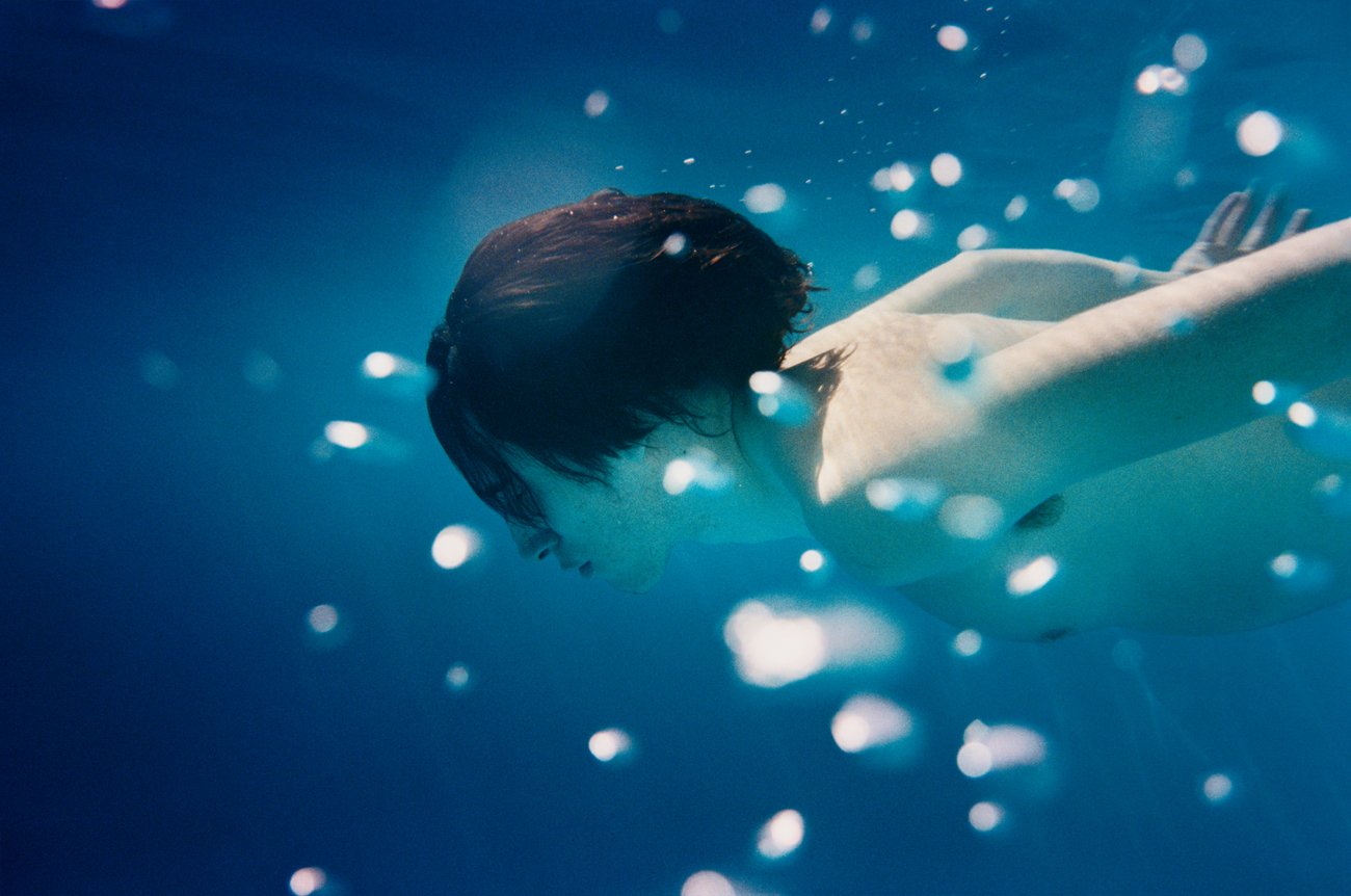 a man swimming underwater in a pool of water