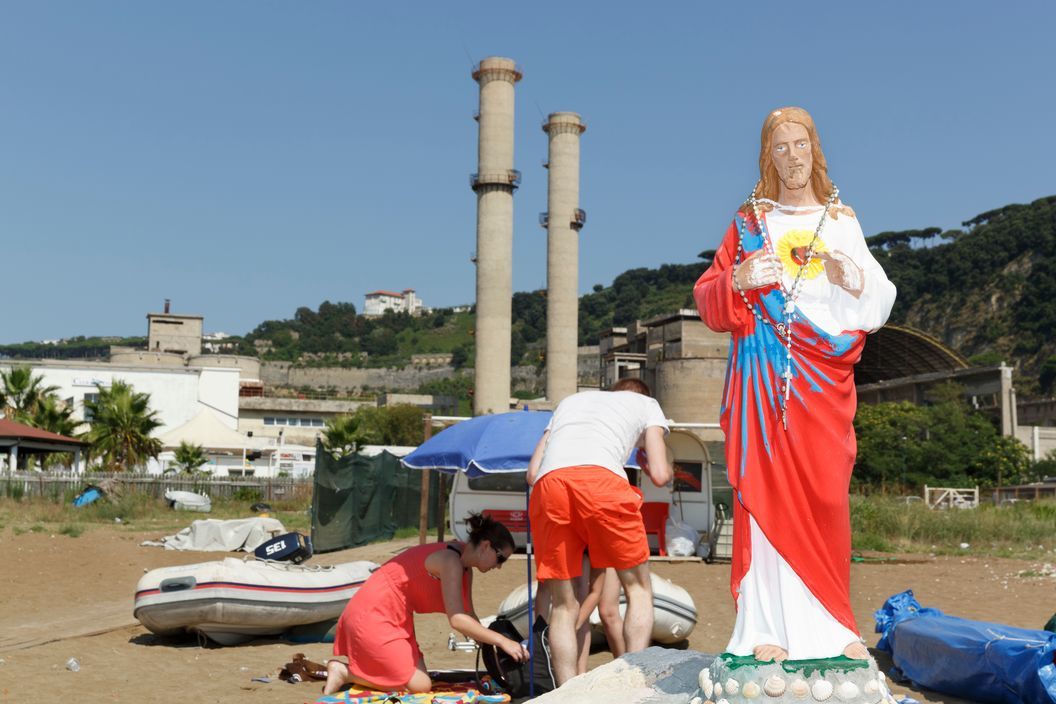 a group of people standing around a statue of jesus