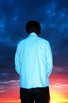 a man standing in front of a sunset