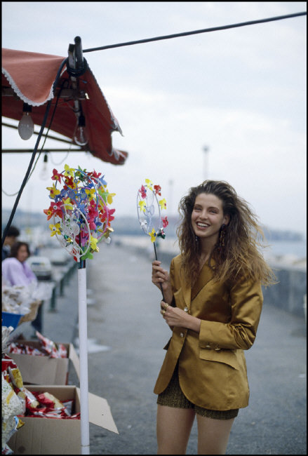 a woman in a yellow blazer holding a flower arrangement