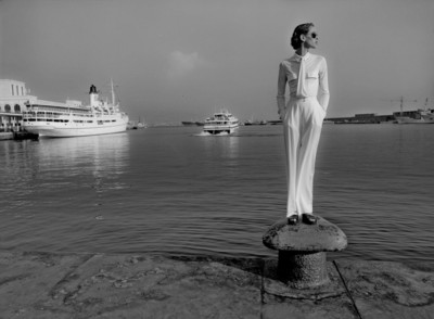 a woman standing on a rock in front of a body of water