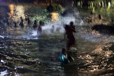 a group of people standing in a body of water