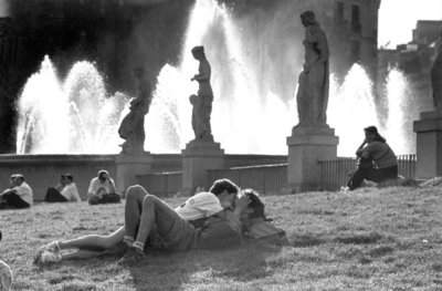 a woman laying on the ground next to a fountain