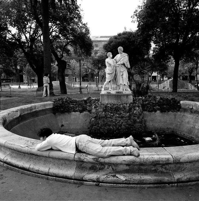 a person laying on the ground next to a statue