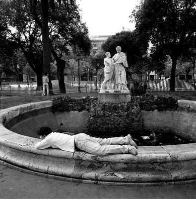 a person laying on the ground next to a statue