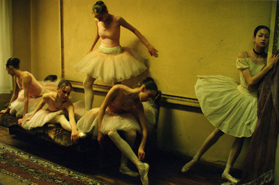 a group of ballerinas sitting on a bed in a room