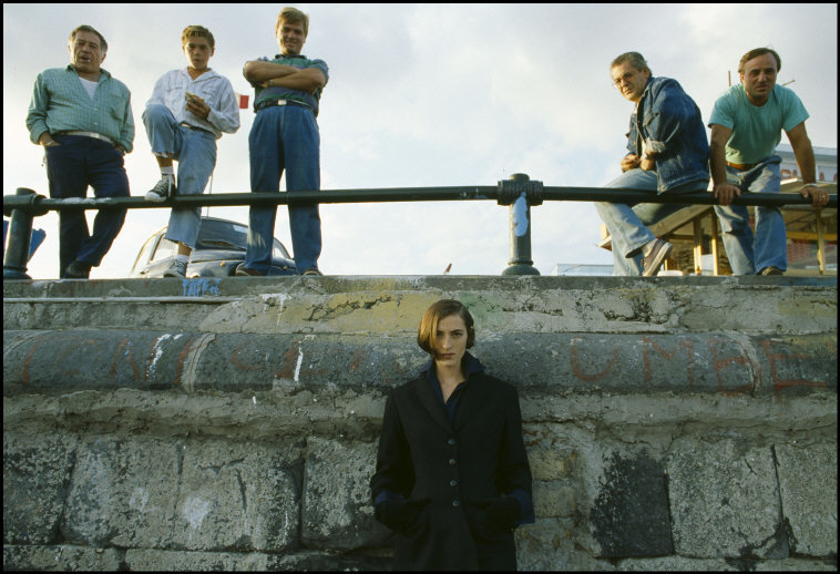 a group of men standing on top of a stone wall