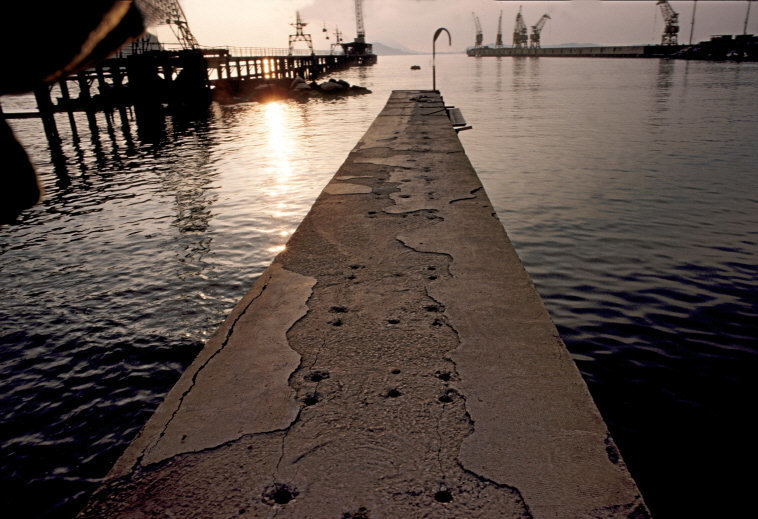 a long dock with a boat in the background