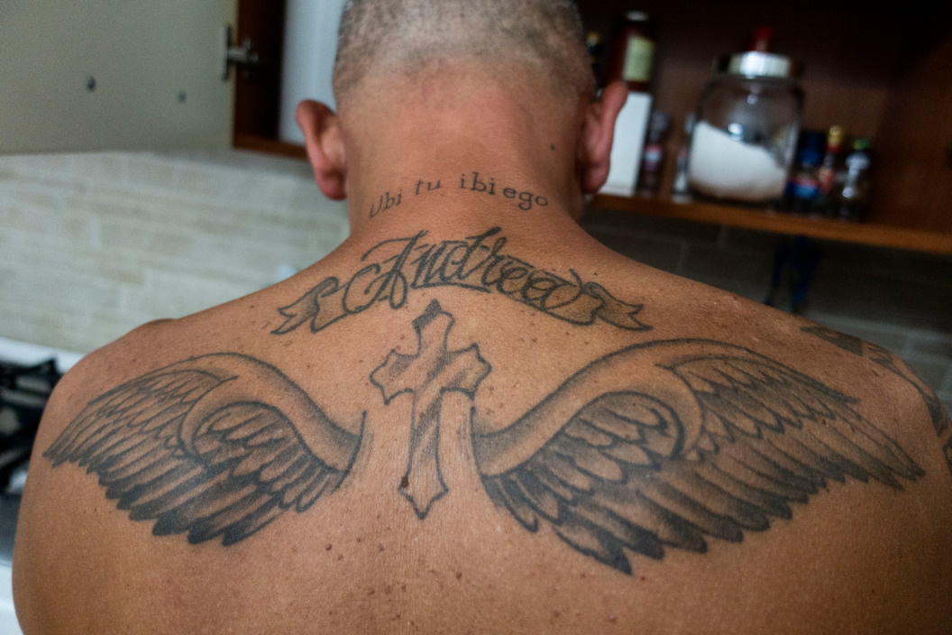 a man with a cross and wings tattoo on his back