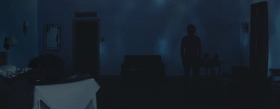 a dark room with a person standing in the corner