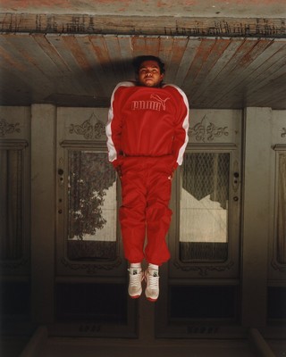 a man in a red jumpsuit hanging upside down