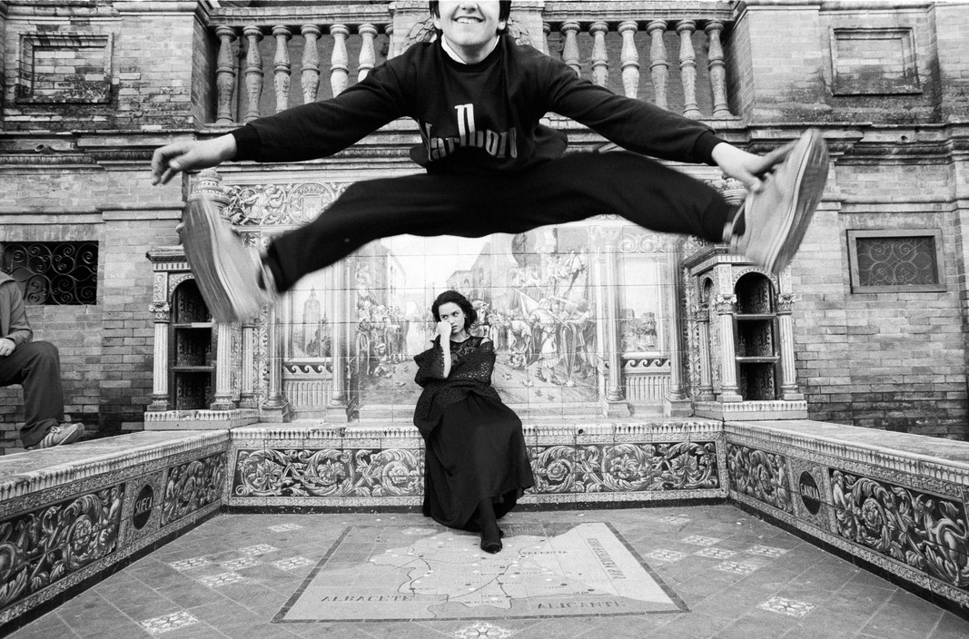 a woman is jumping in the air in front of a building