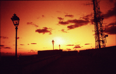 the sun is setting over a train track