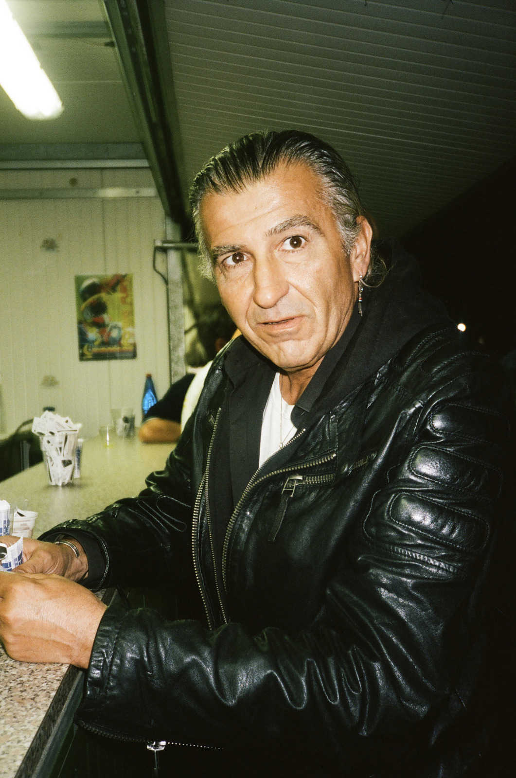 a man sitting at a bar with a drink in his hand