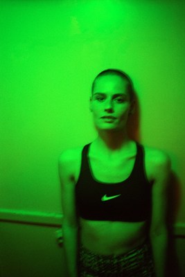 a woman standing in front of a green wall