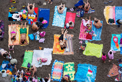 a group of people laying on top of a sandy beach