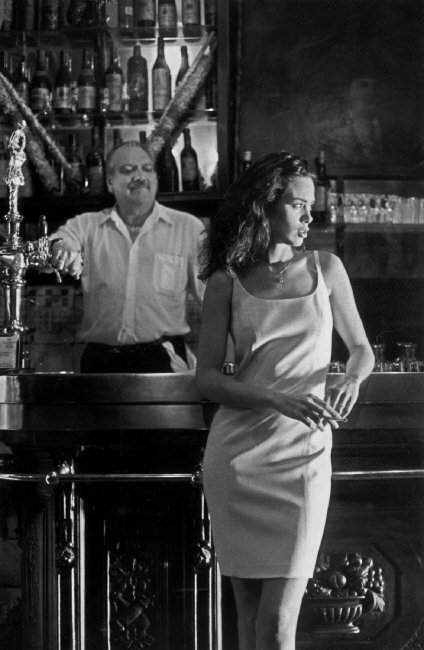 a man and a woman standing in front of a bar