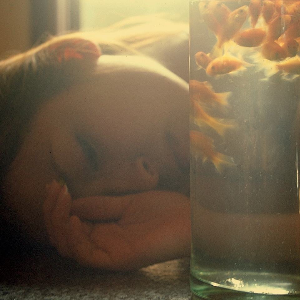 a woman laying down next to a glass of water