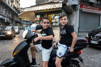 a couple of kids that are sitting on a scooter