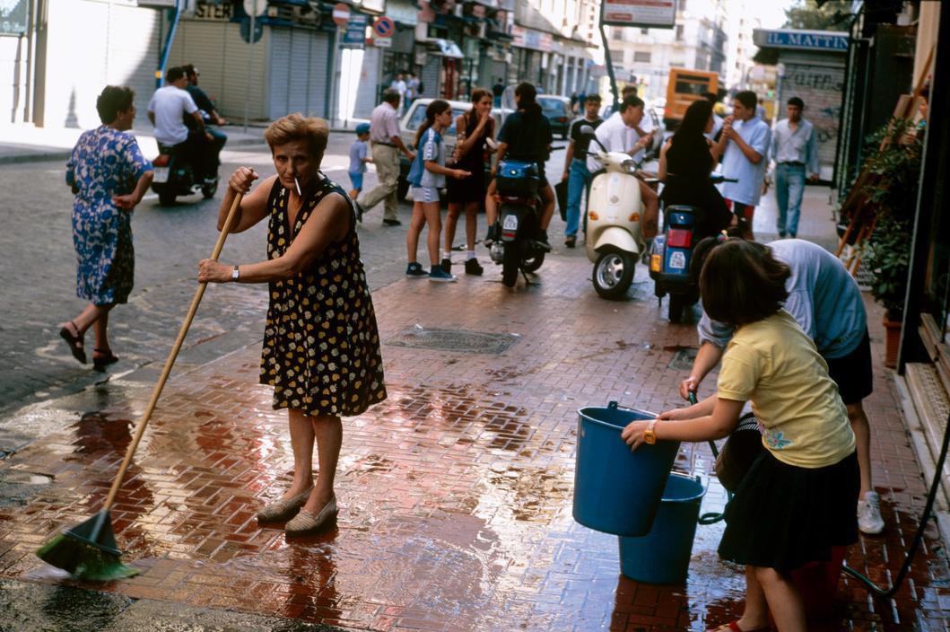 a woman and a child are cleaning the street