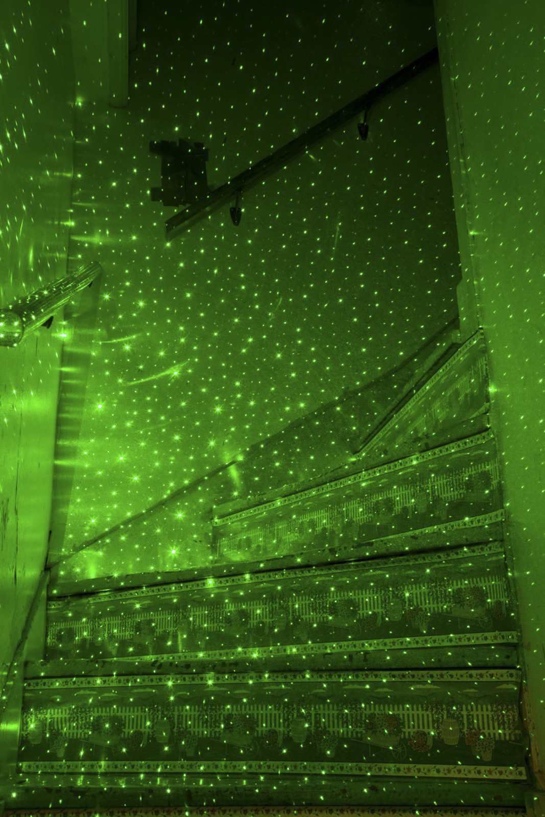 a staircase covered in green lights in a room