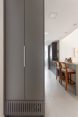 a room with a large gray cabinet next to a dining room table