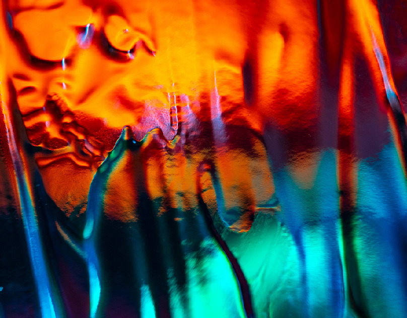 a close up of a glass with a colorful background