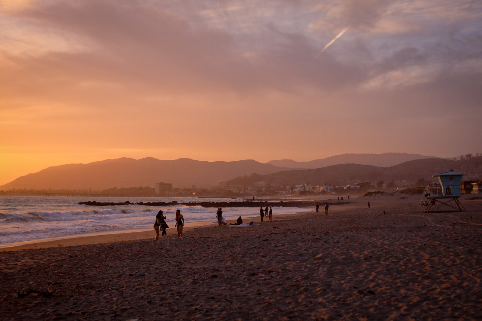 a group of people standing on top of a sandy beach