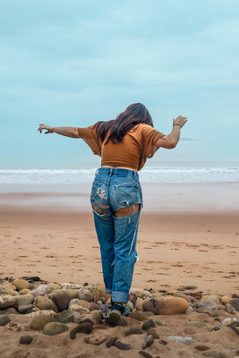 a woman standing on top of a sandy beach