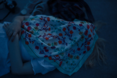 a little girl laying in bed under a blanket