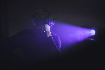 a person standing in front of a purple light