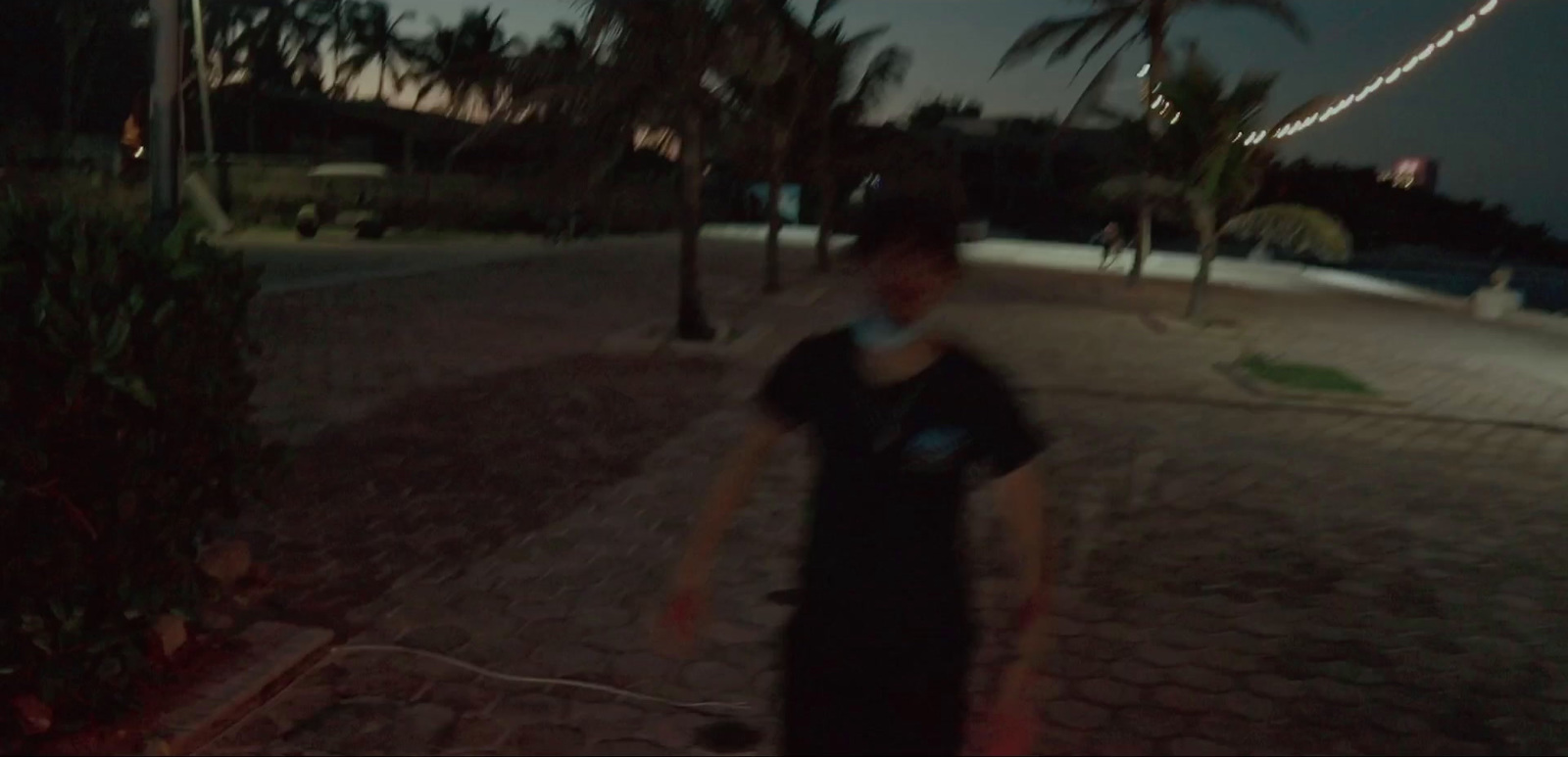 a man standing on a sidewalk at night