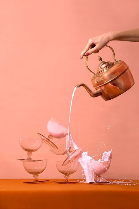 a person pouring water into three glasses on top of a table