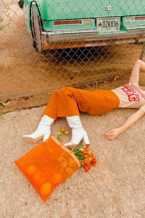 a woman laying on the ground next to a car