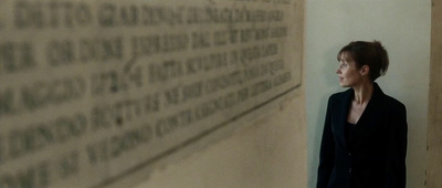 a woman standing in front of a wall with writing on it